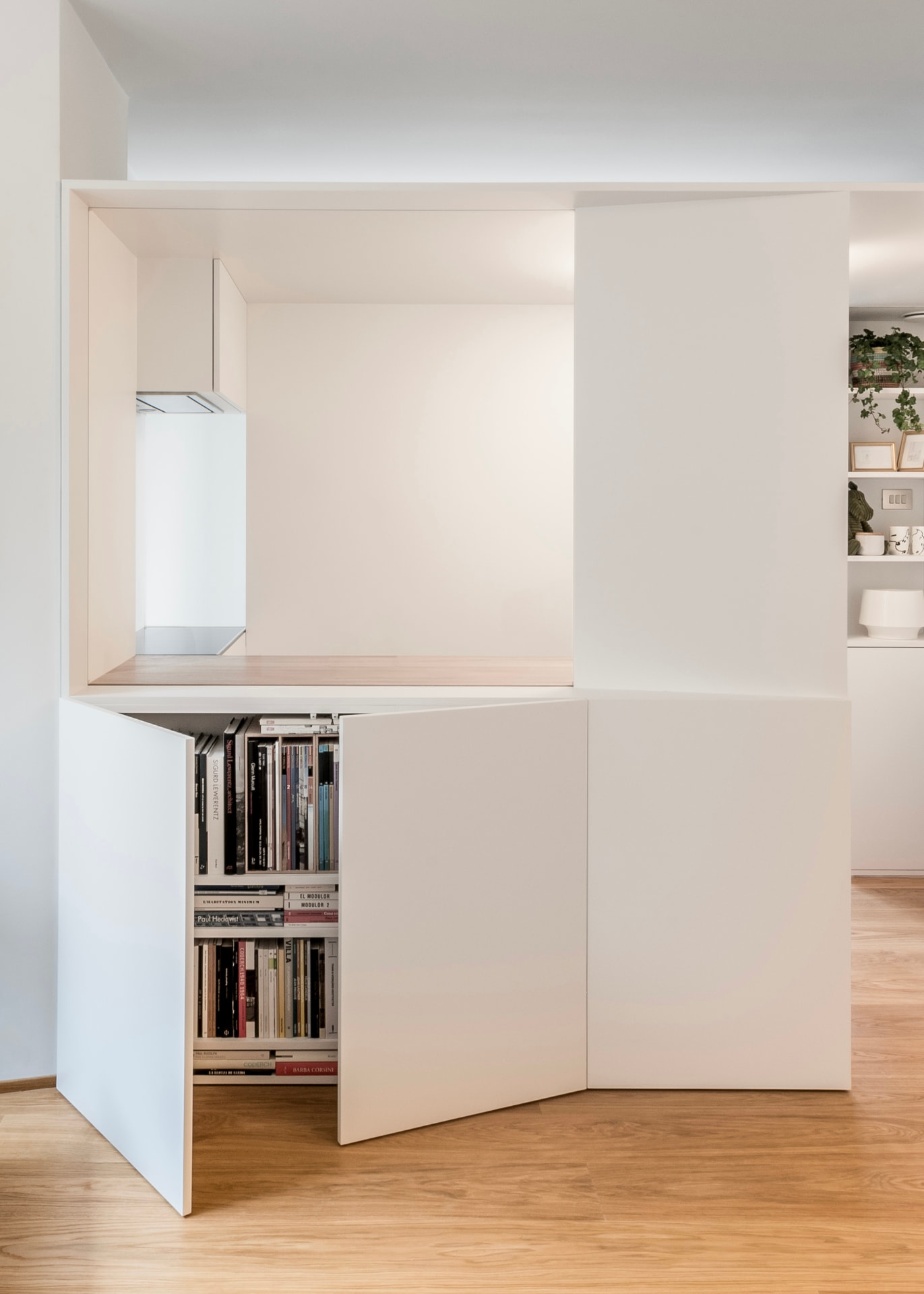 Moble blanc de portes plegables amb llibres a l’interior